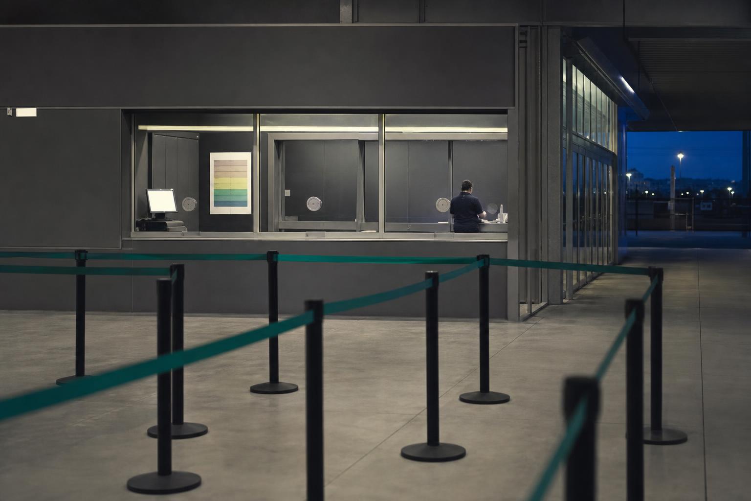 An empty ticket queue and fee chart stand in for the new arithmetic of concert pricing.